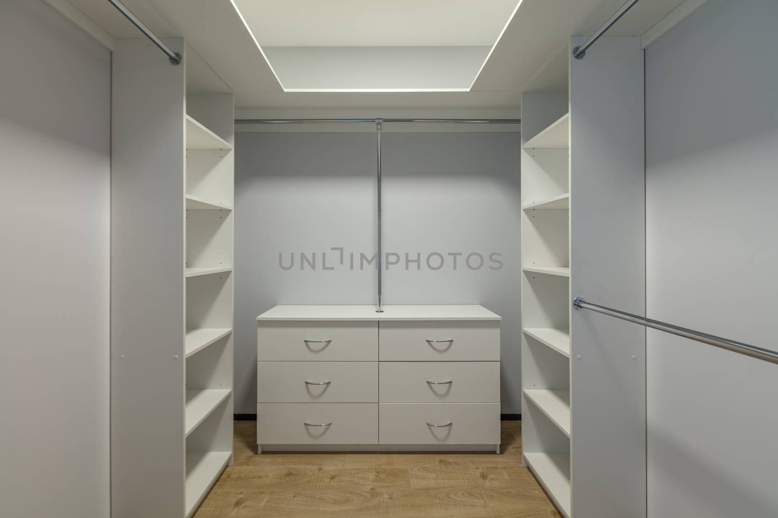 Inside of the empty modern walk-in wardrobe open door