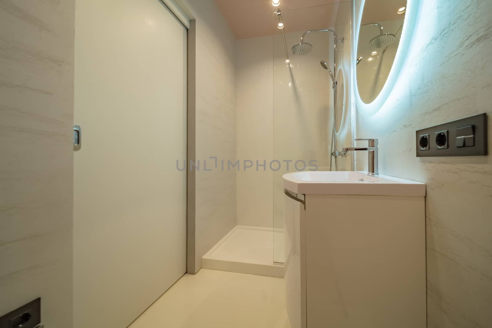 Small beige tile bathroom with Shower cabin and sink