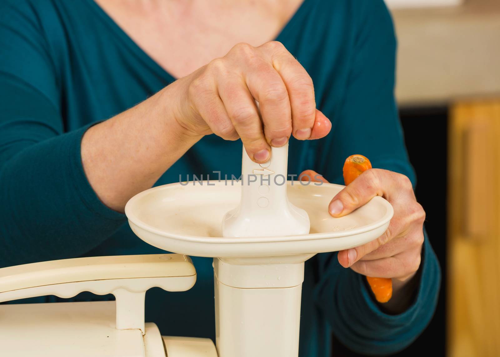 Woman using a centrifuge machine to prepare a detox juice. 