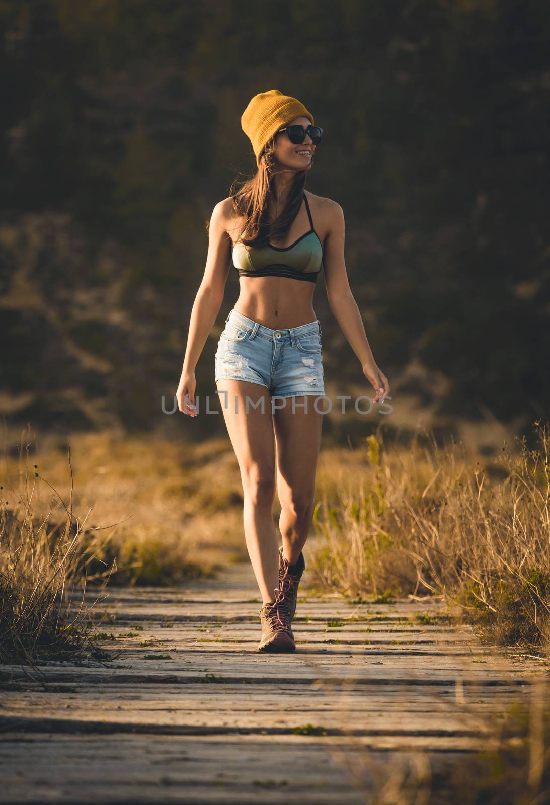 Beautiful young woman walking over a wood path
