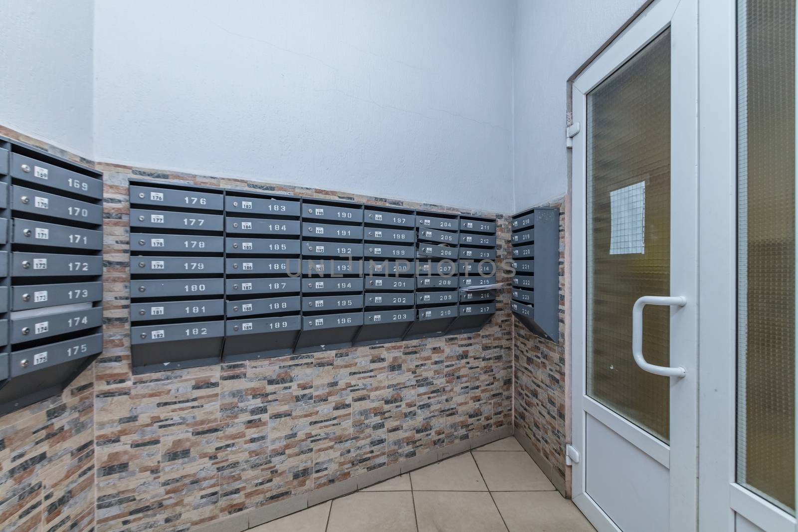 row of gray mailboxes in corridor of apartment building