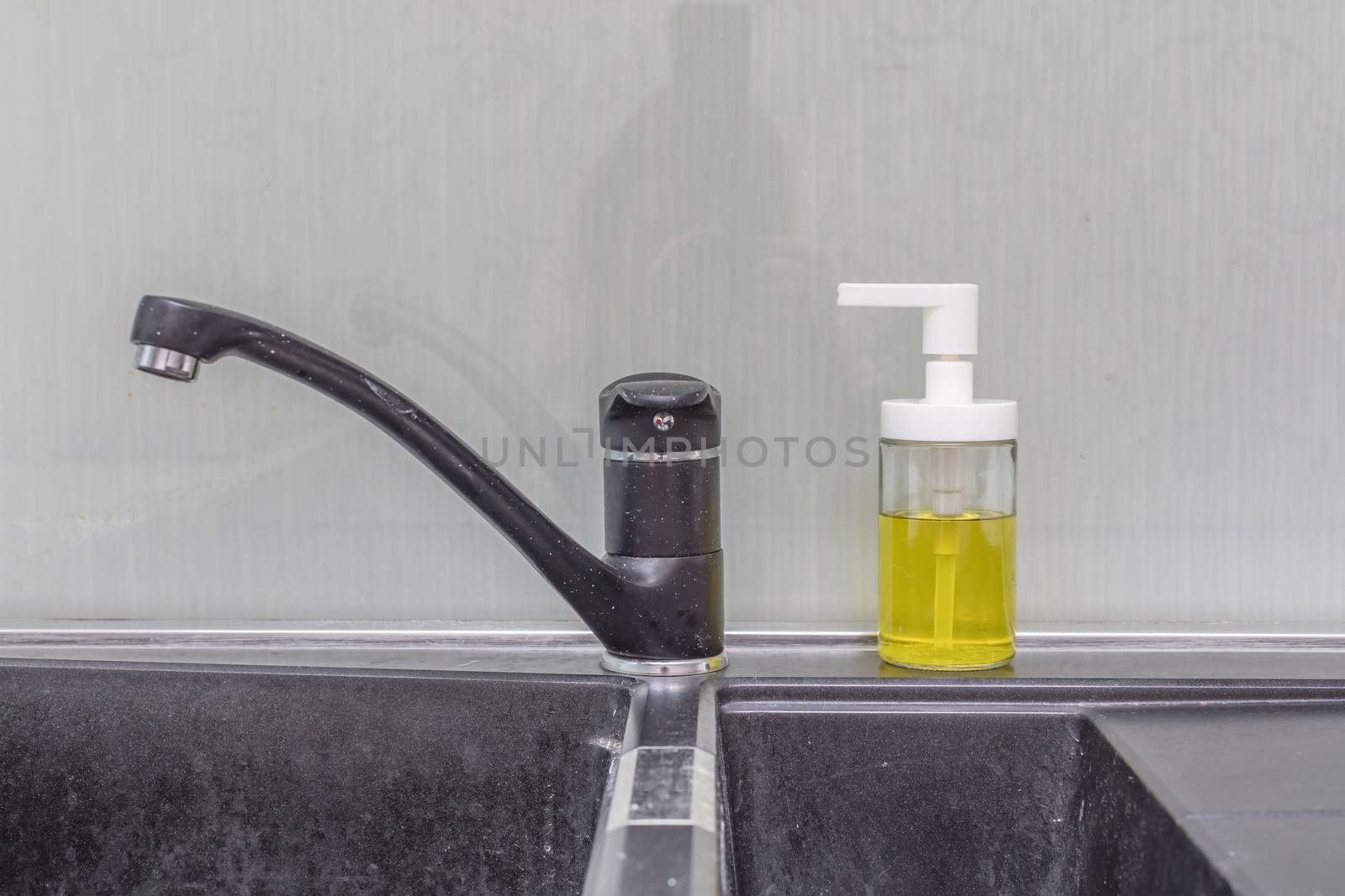 Close up of modern faucet and ceramic sink in kitchen