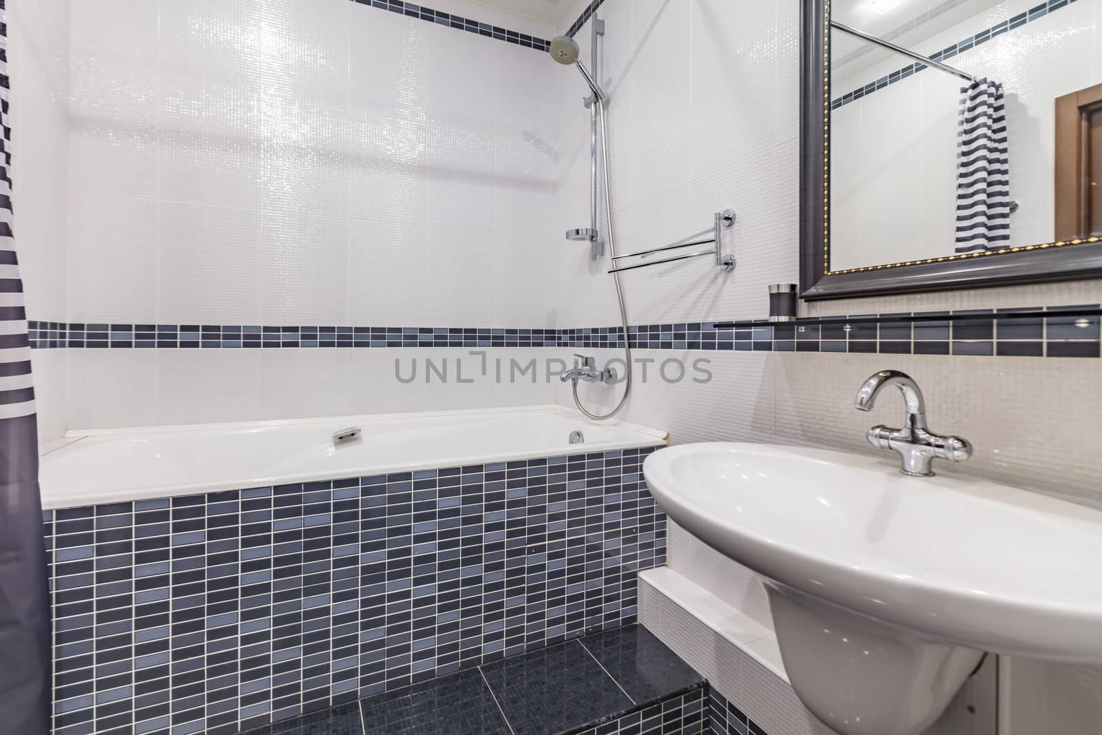 Small grey tile bathroom with bath tube and sink
