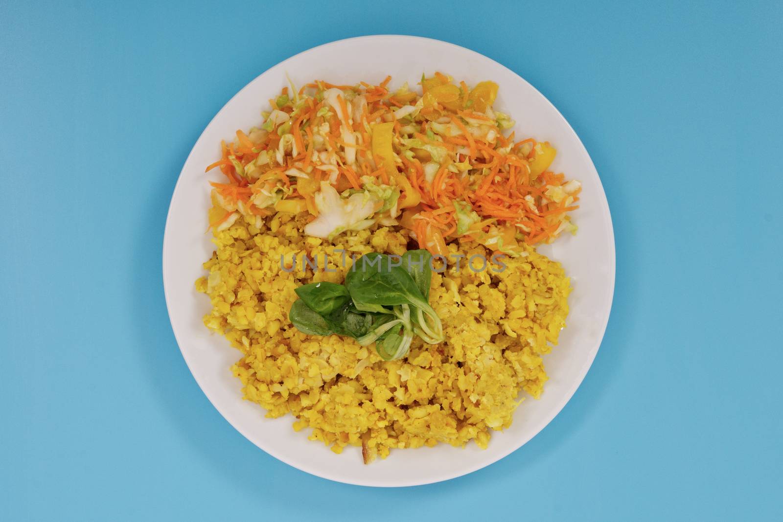 Baked Bulgar with cauliflower and vegetable salad on a blue background