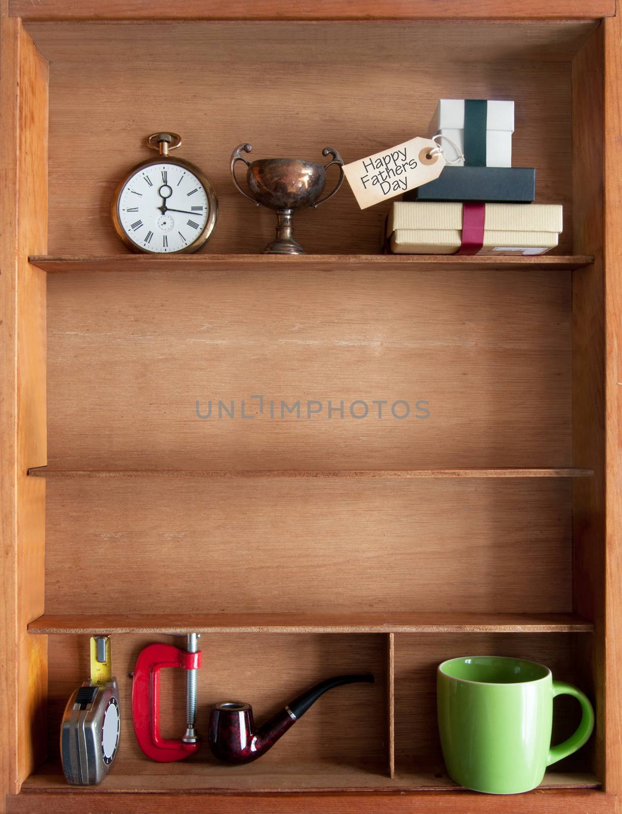 Fathers day gift with label inside a shelf with various objects including tools and coffee cup