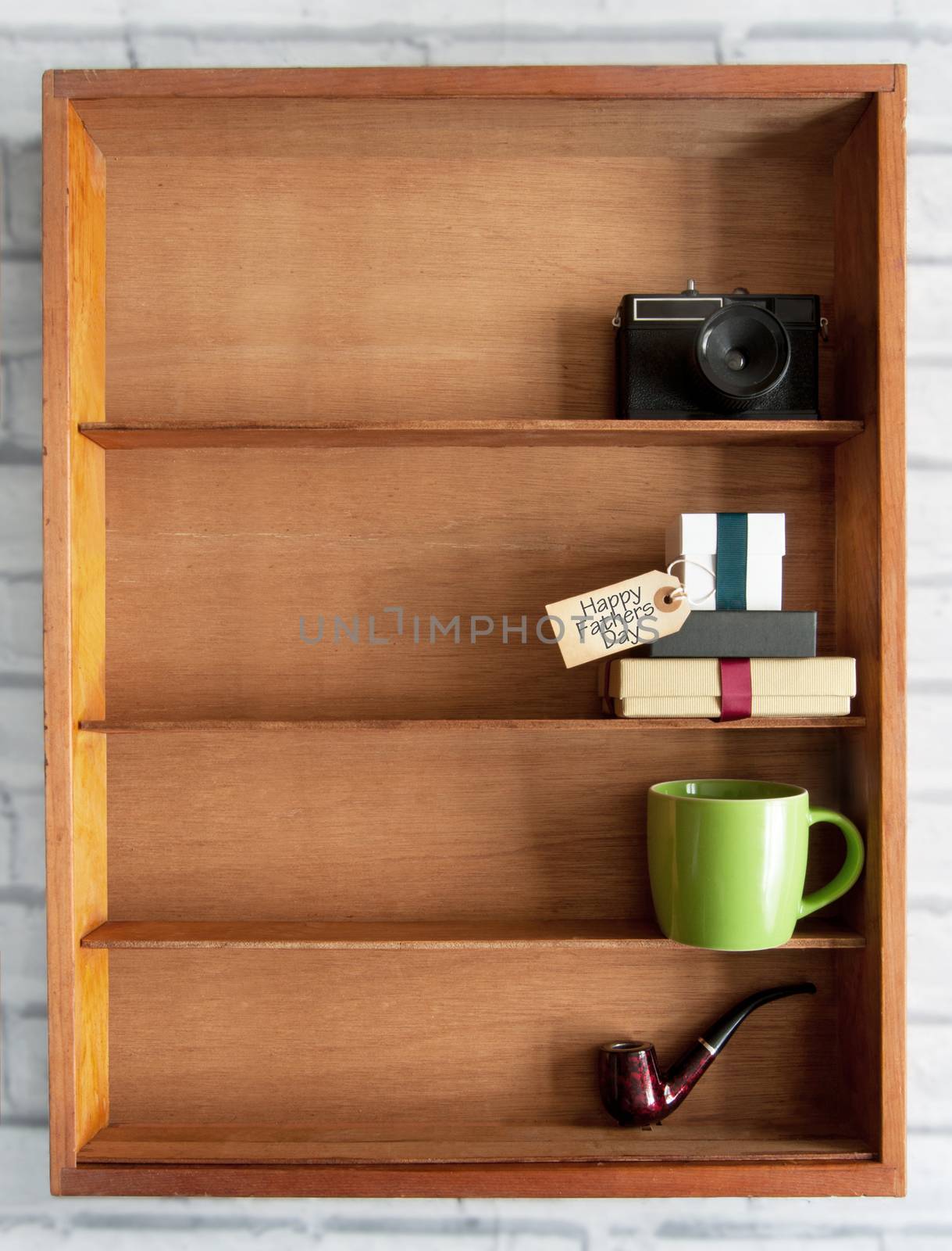 Gift boxes with fathers day label inside a display shelf with coffee cup and pipe