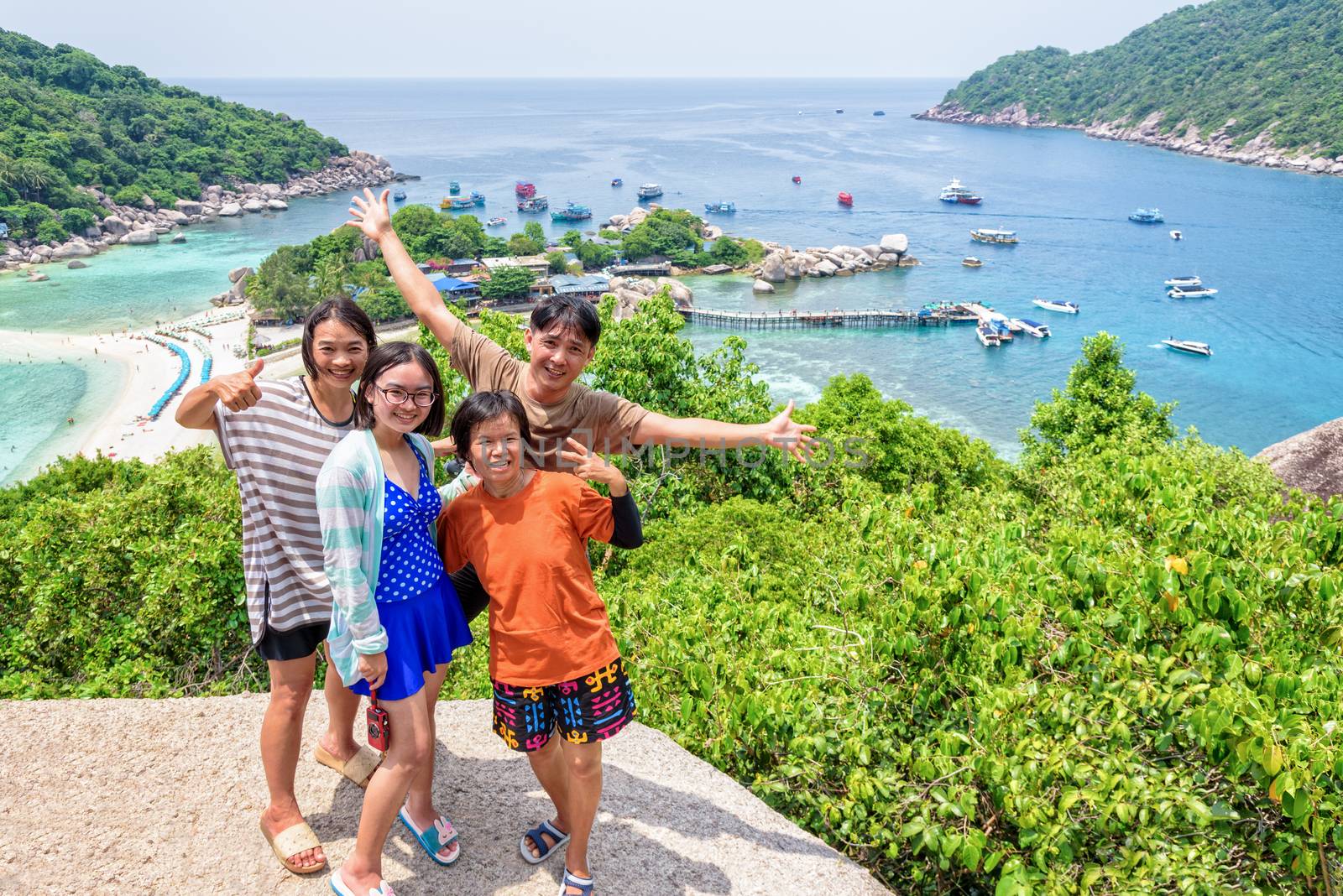 Thai family tourists is posing happily on top of the Koh Nang Yuan island is a high viewpoint and beautiful natural landscape is a famous attractions in the Gulf of Thailand, Surat Thani, Thailand