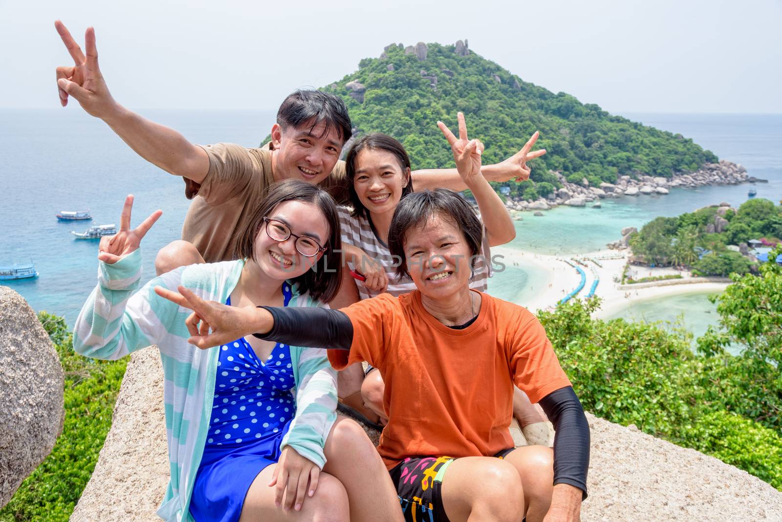 Thai family tourists is posing happily on top of the Koh Nang Yuan island is a high viewpoint and beautiful natural landscape is a famous attractions in the Gulf of Thailand, Surat Thani, Thailand