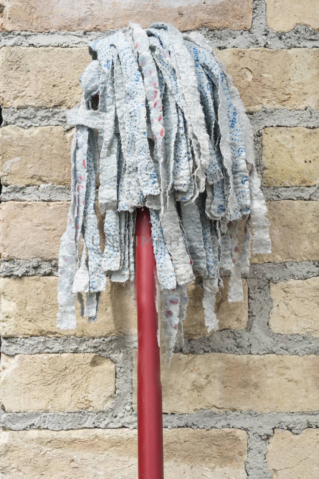 a rag for cleaning the floors resting on the wall