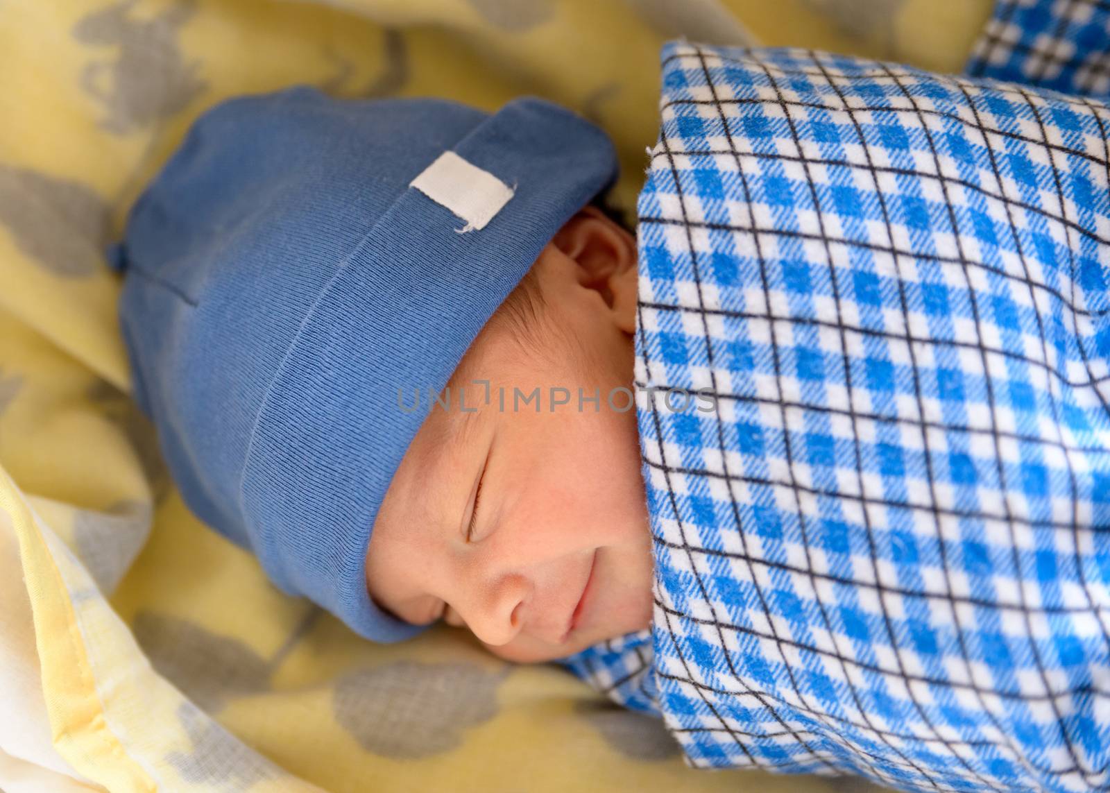 Cute Eurasian newborn baby smiling in his sleep