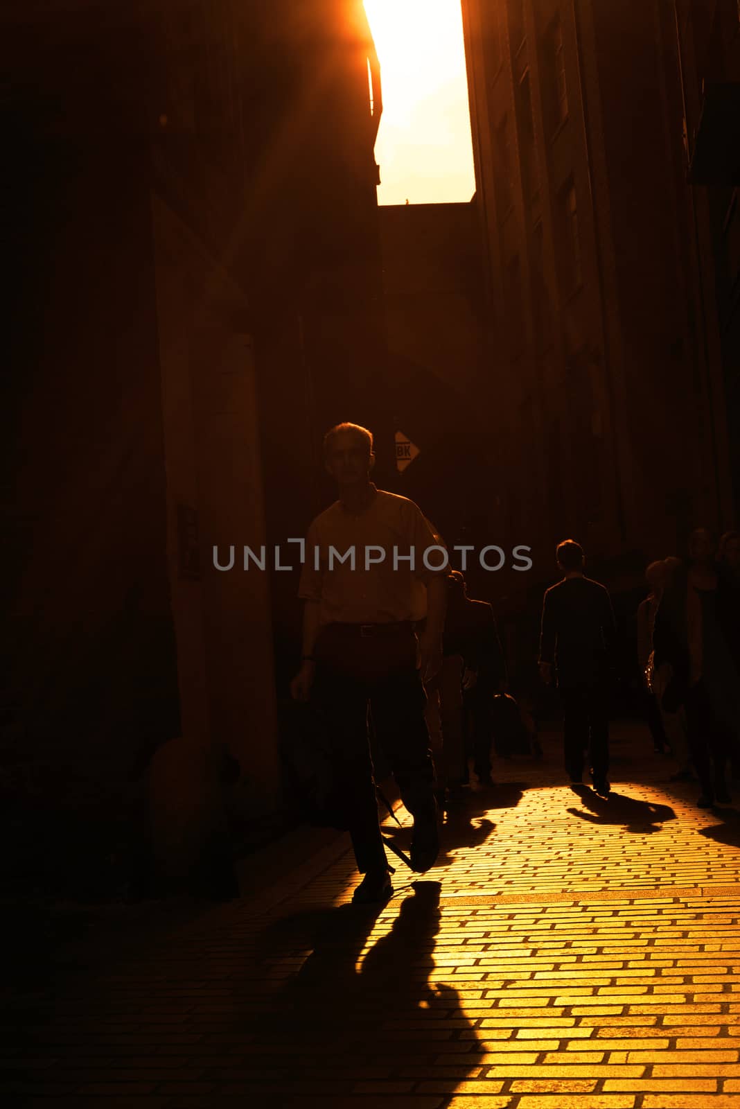 commuters walking down a cobbled lane by morrbyte