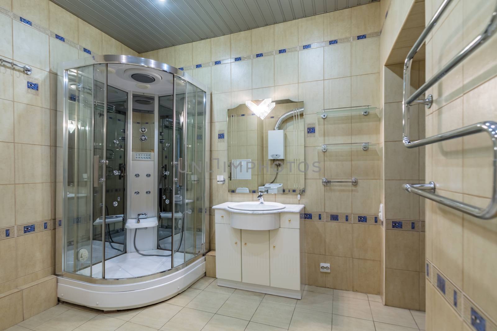 Small beige tile bathroom with Shower cabin and sink