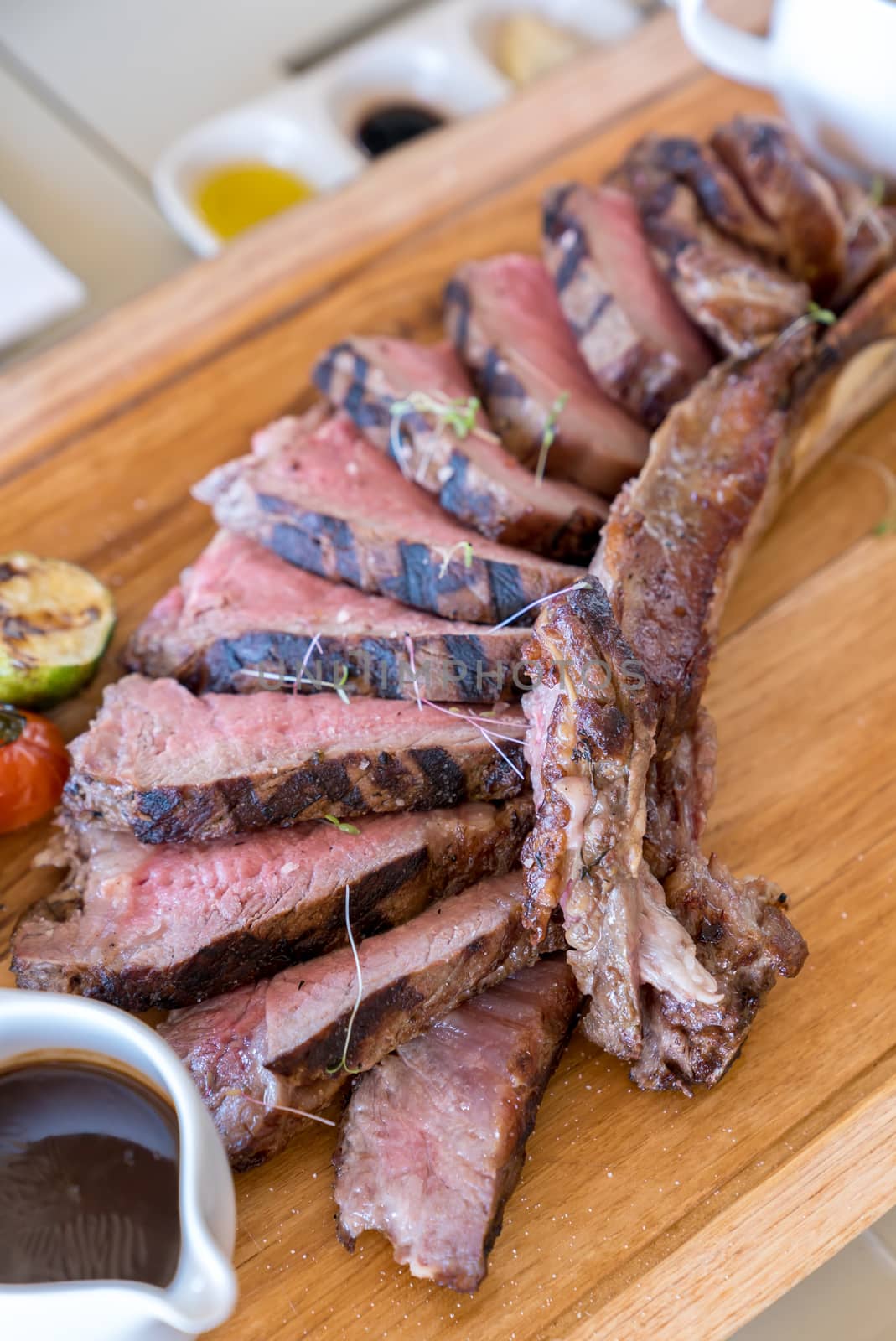 Grilled tomahawk steak on wooden plate