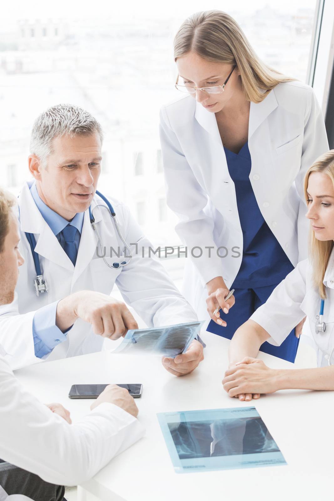 Group of doctors look and discuss x-ray in a clinic or hospital