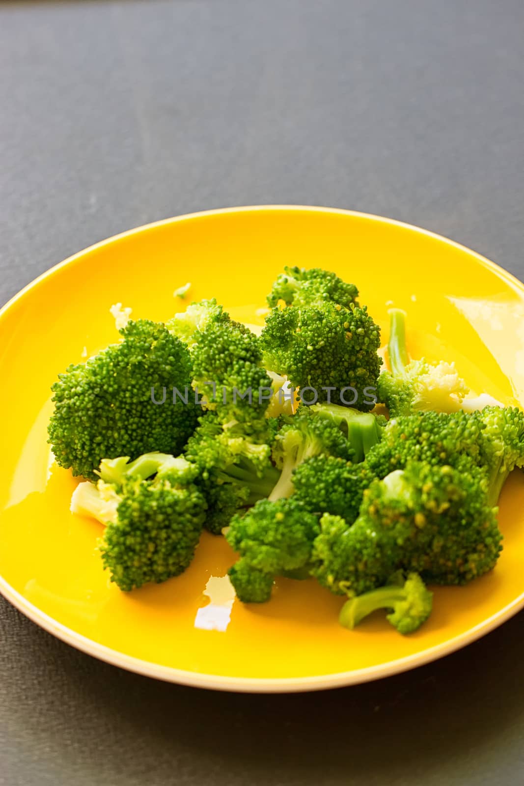 Fresh broccoli cut in yellow plate by victosha