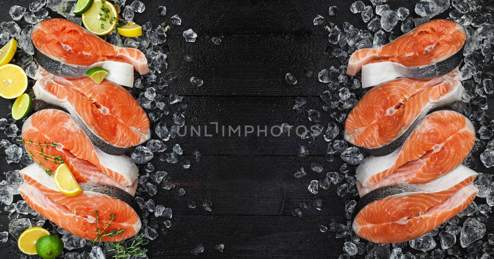 Fresh salmon steaks on ice, on black background. Top view, copy space