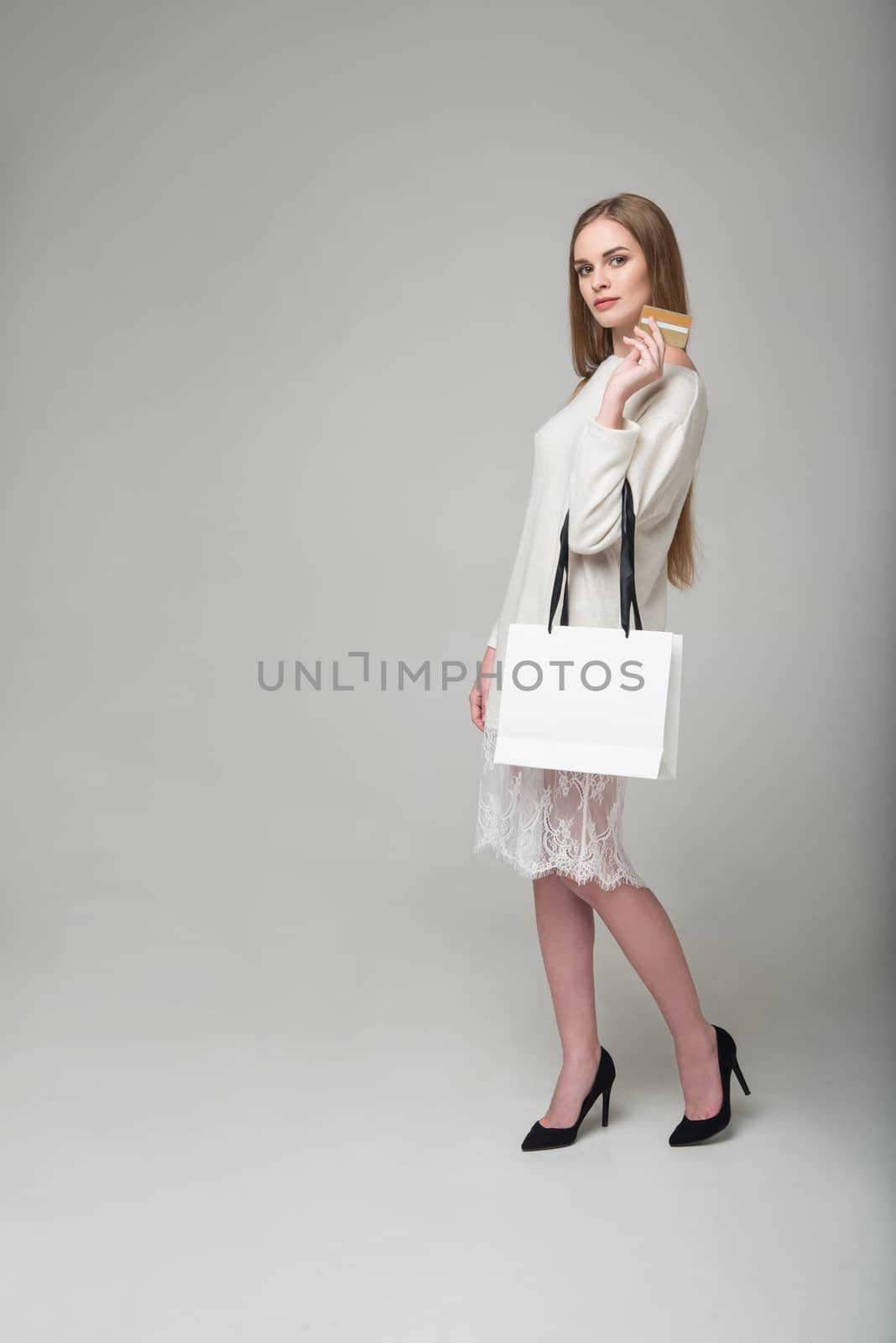 Blond woman in white lace short dress with shopping bag by VeraVerano