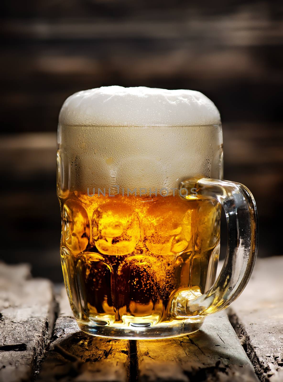 Beer in mug on wooden table and dark background
