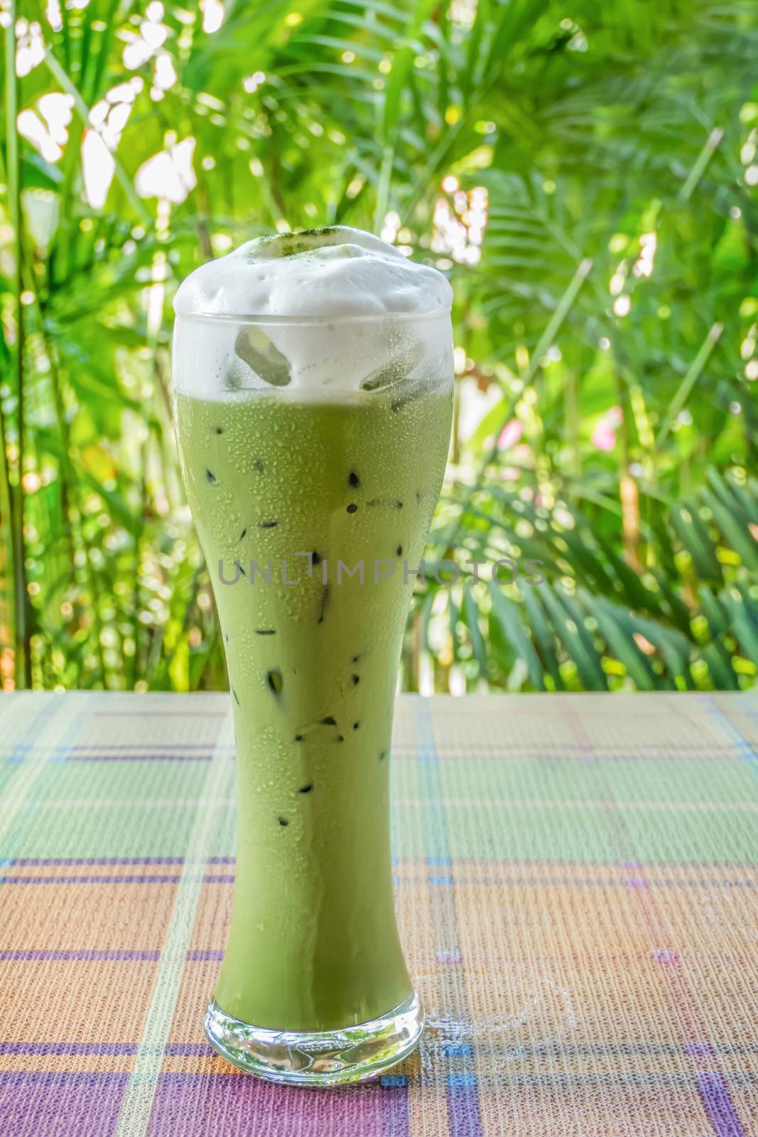 iced milk green tea on table with nature background