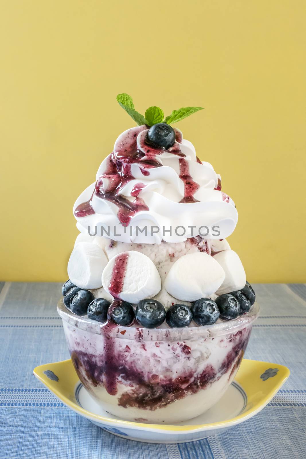 Bingsu - Korean shaved ice dessert with sweet toppings with marshmallow and blueberries