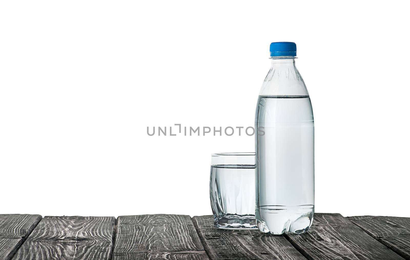 Plastic bottle and a glass with water. Wooden table. Isolated on white background.