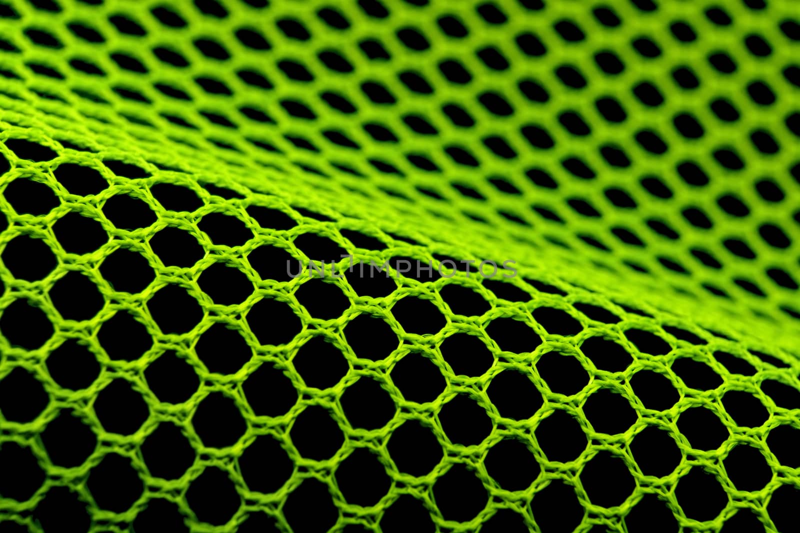 green hexagonal textile mesh on black background