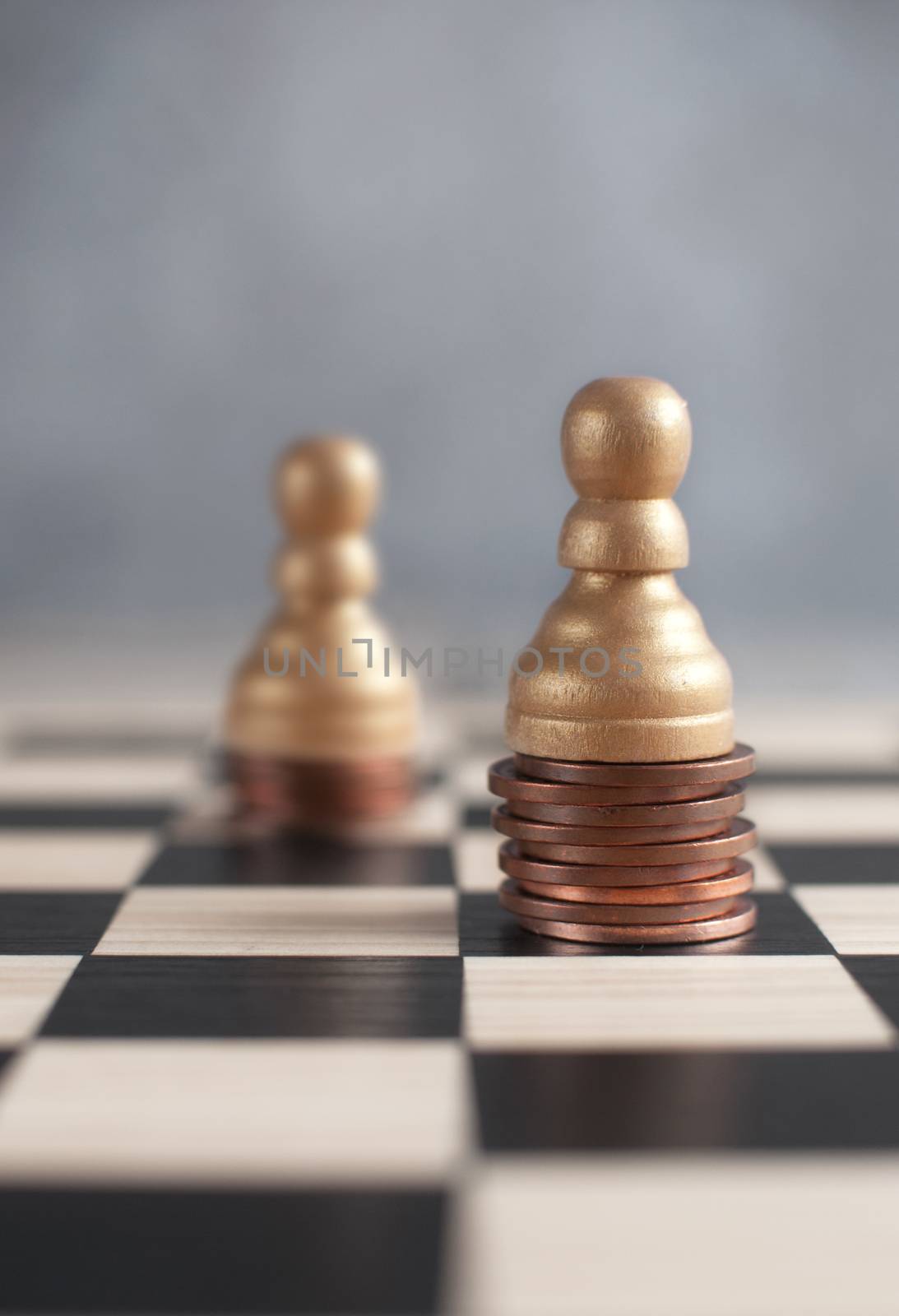 Two chess pawns on top of coins 