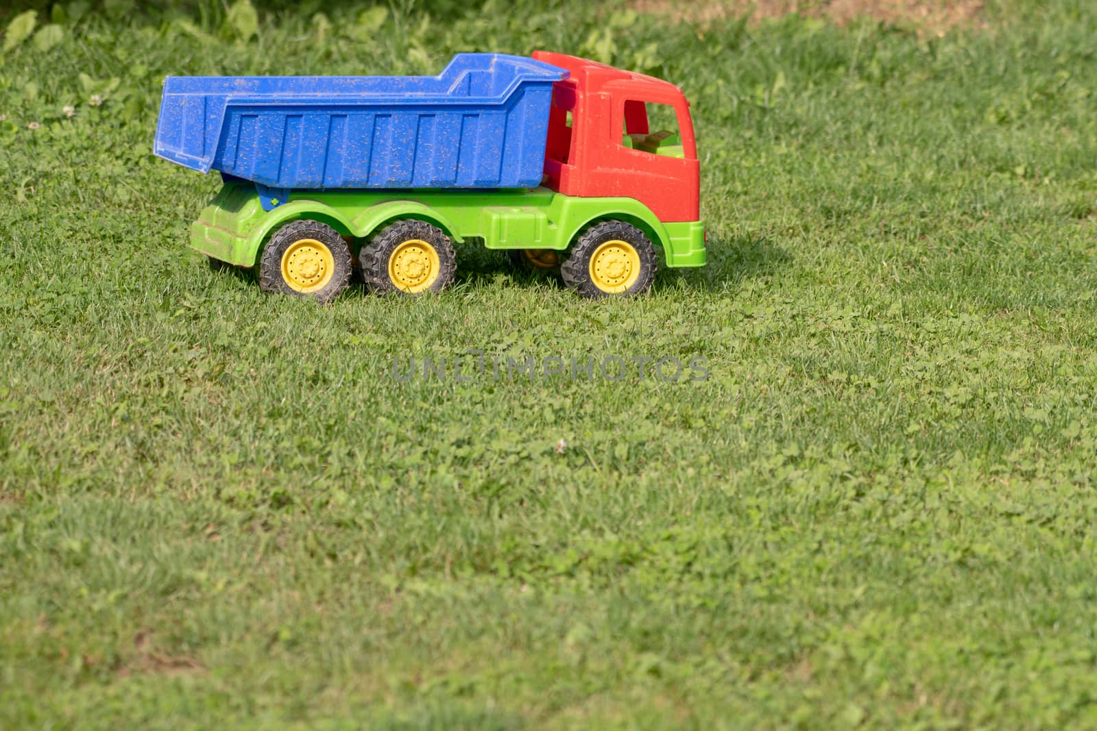 Toy truck on grass, abandoned toy by asafaric