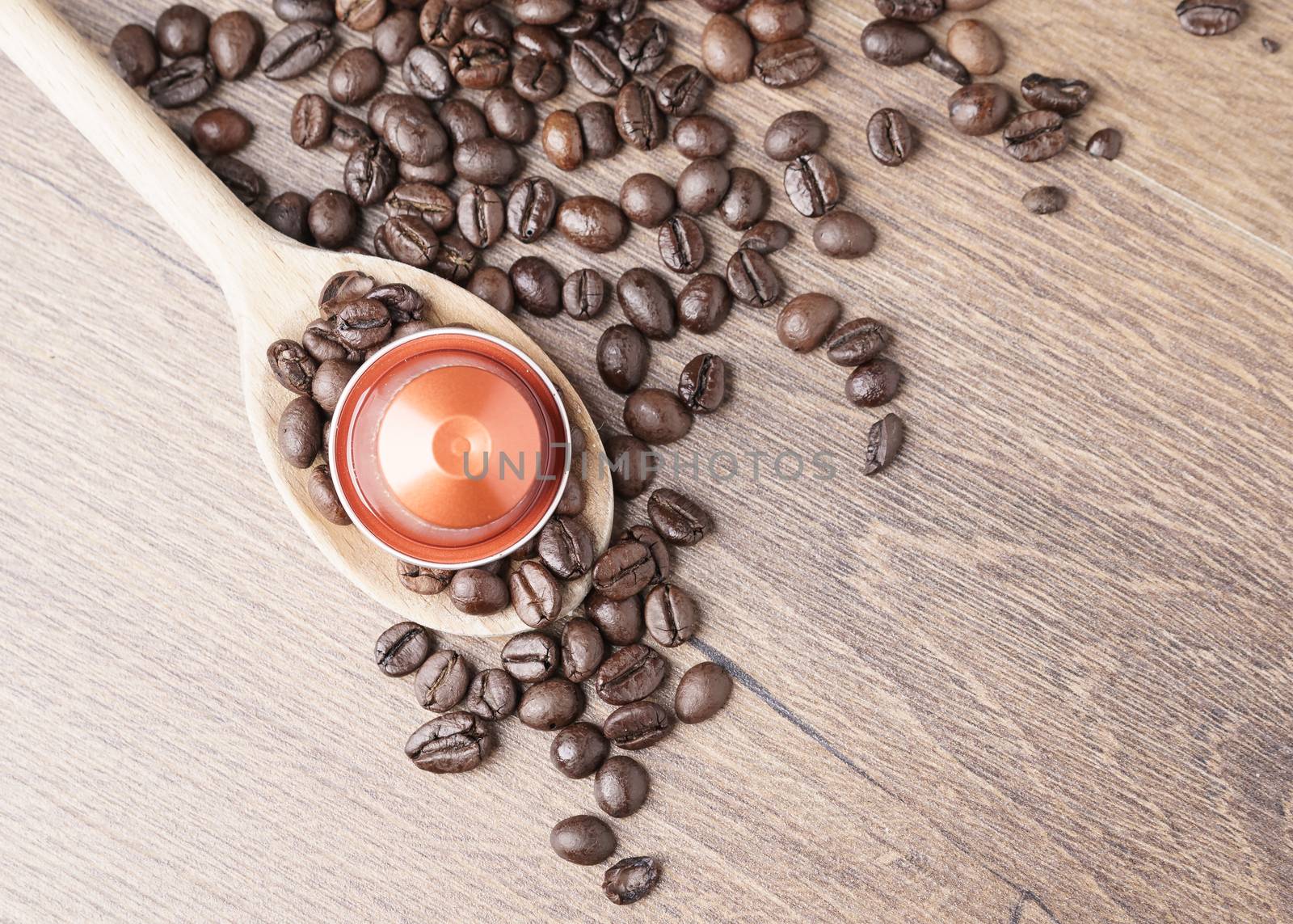 coffee capsule on wooden spoon and coffee beans by Robertobinetti70