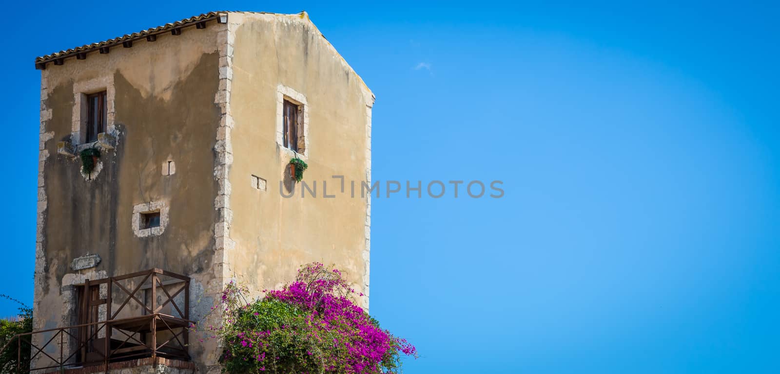 Traditional old Sicilian house during a sunny day with a wonderful blue sky background.