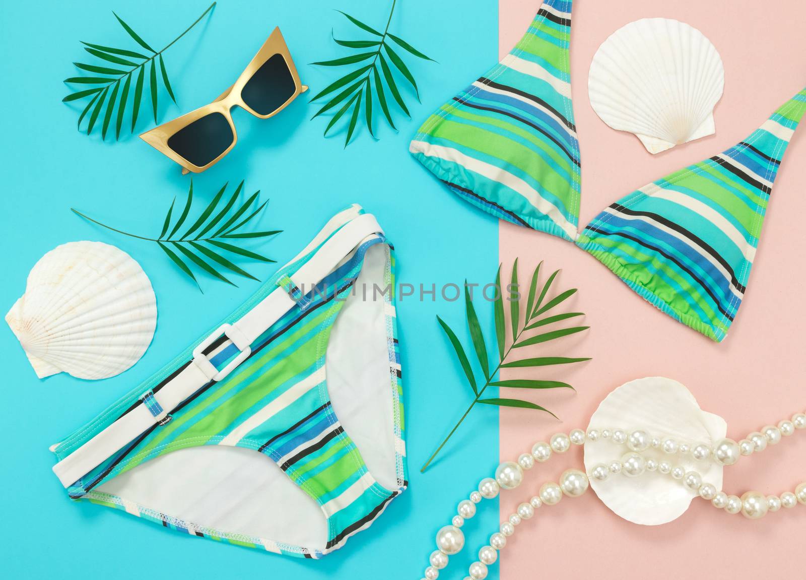 Tropical vacation flat lay on turquoise and pink background. Summer fashion.