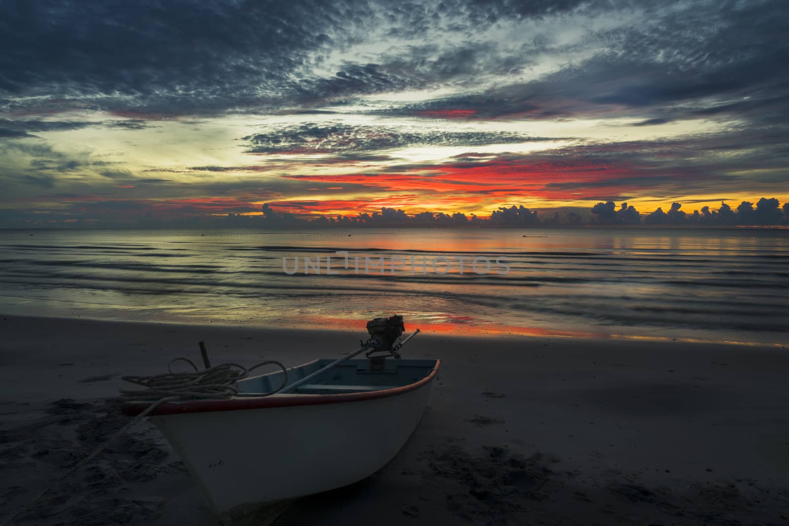 A beautiful dawn on a topical beach with a boat.