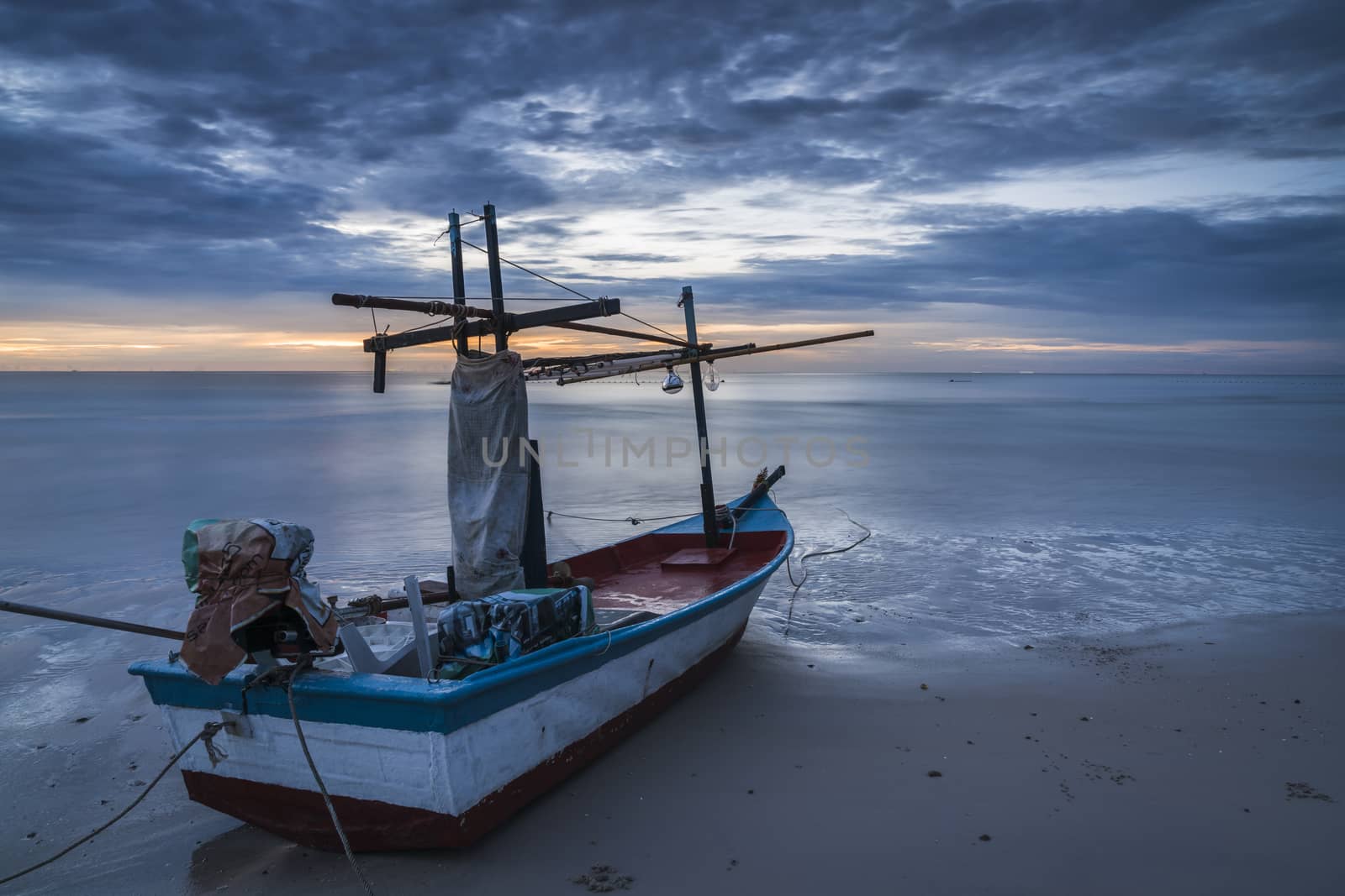 A fishing boat on beach in dawn.