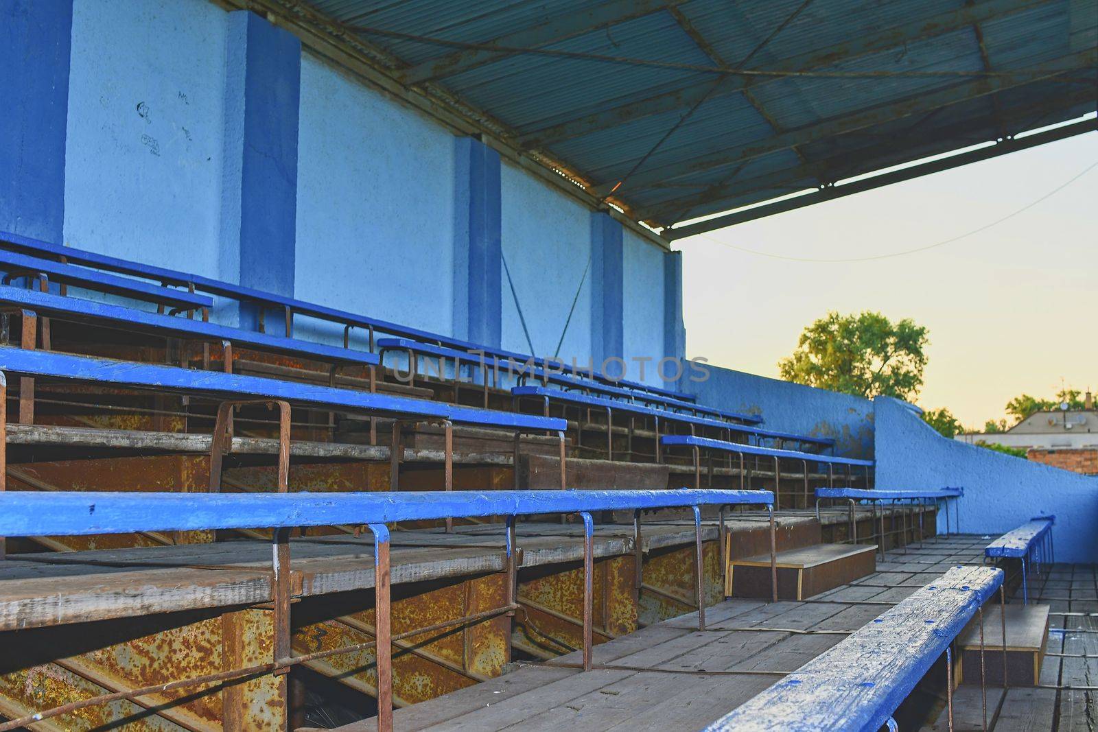 Old grandstand seats. Vintage tone. Old blue wooden grandstand stadium.