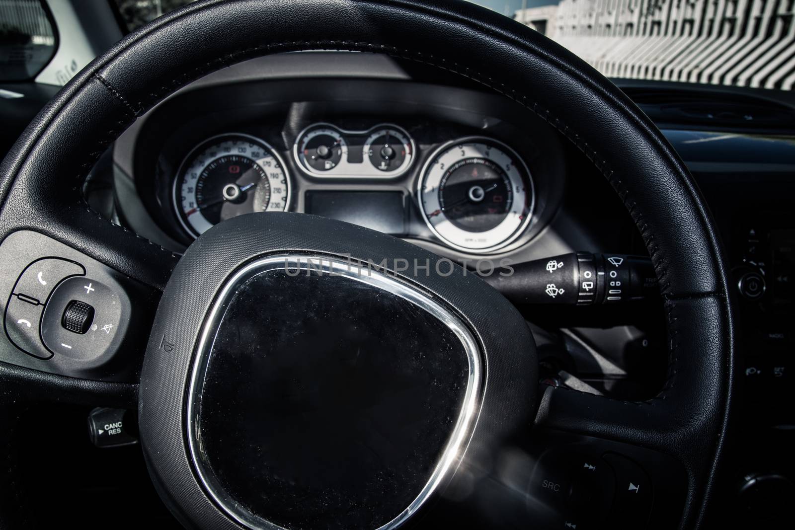 Closeup of car steering wheel and dashboard. Modern car interior details.