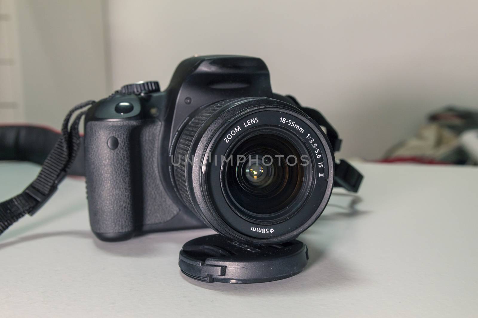 Closeup of modern black DSLR camera on white table.