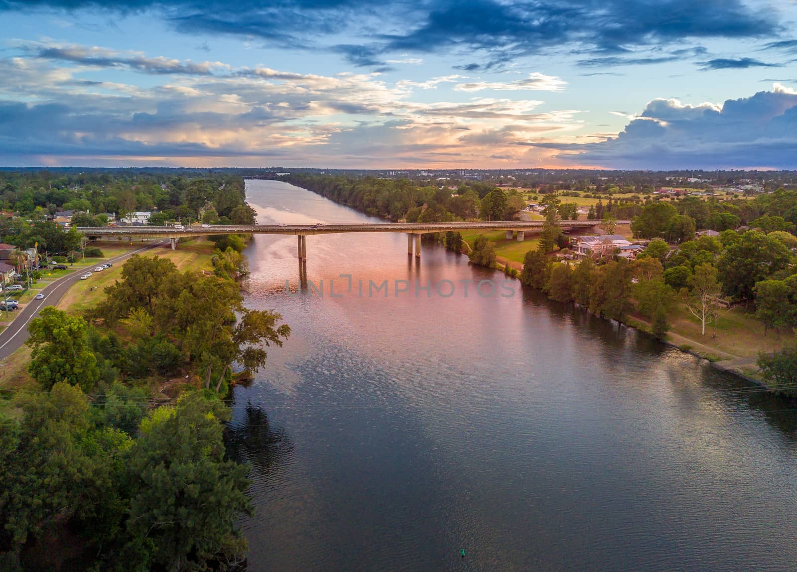 Scenic views early morning along the Nepean River as is leaves the gorge into the plains and  makes its long journey to the sea.  A bridge for cars and pedestrians crosses in the mid ground.