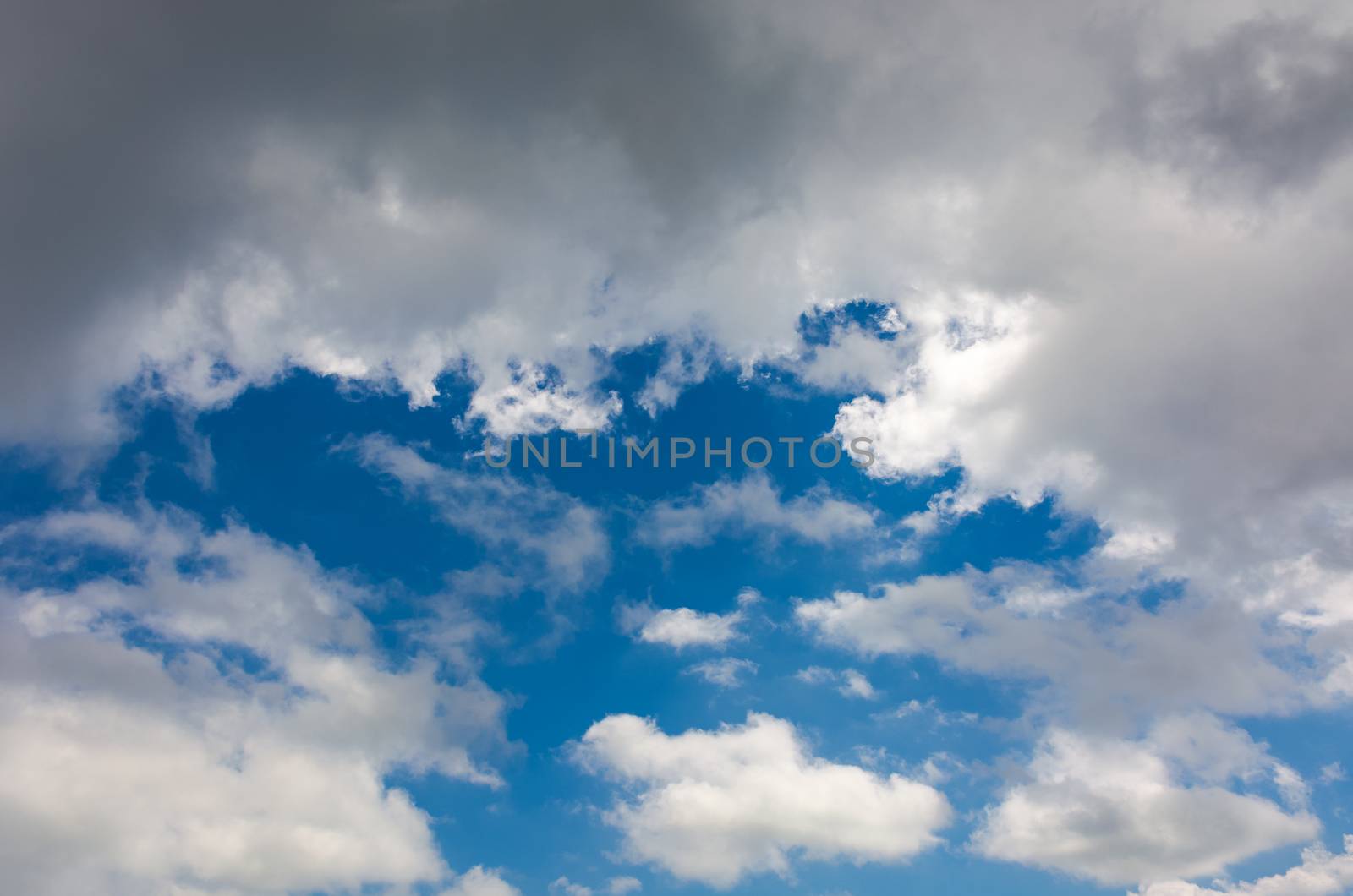 amazing cloud formations on a dark blue sky. beautiful side lit cloudscape panorama in summer