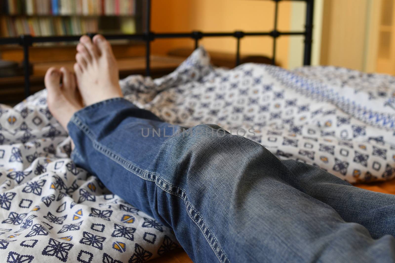 Men feet alone in a bed. Men's feet. Colored background. Close up by roman_nerud