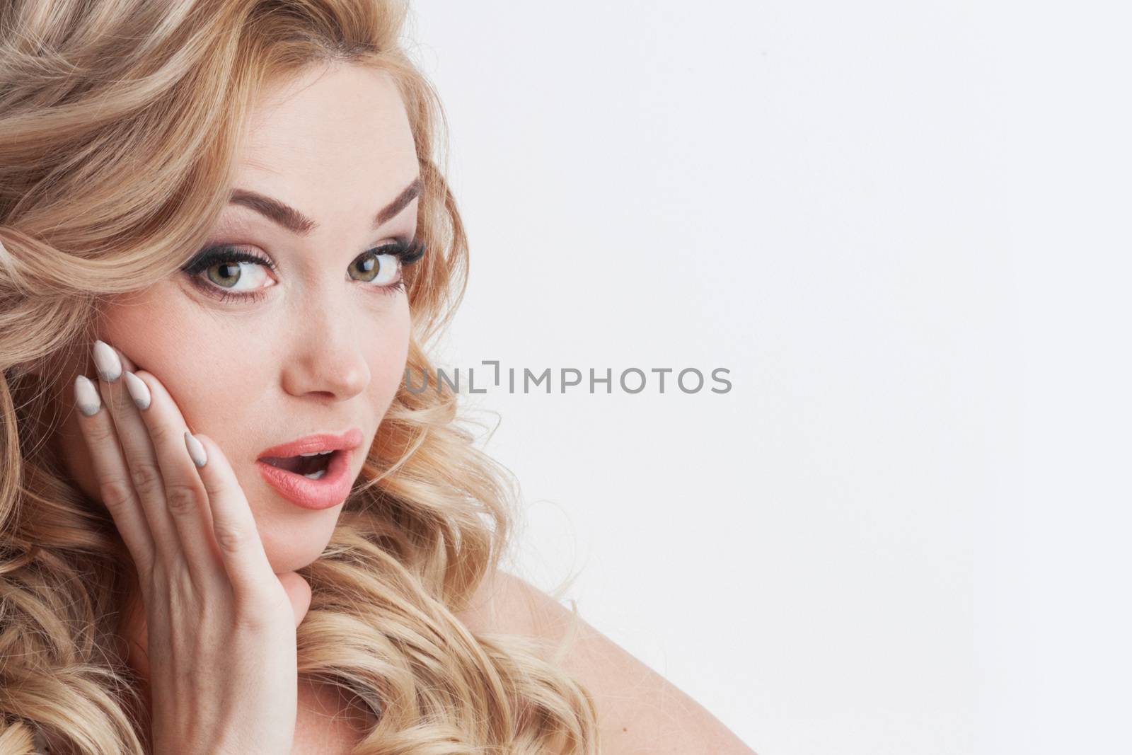 Close-up portrait of surprised beautiful girl with hand on face