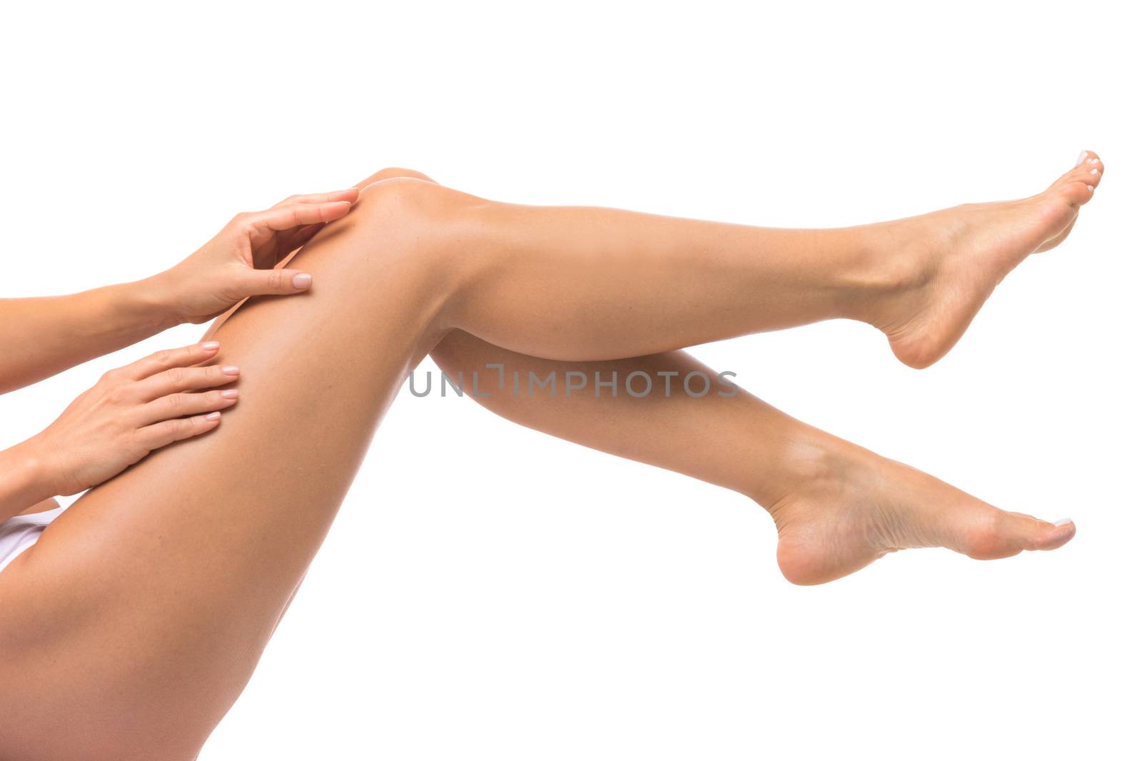Beautiful female legs touched by hand , isolated on white
