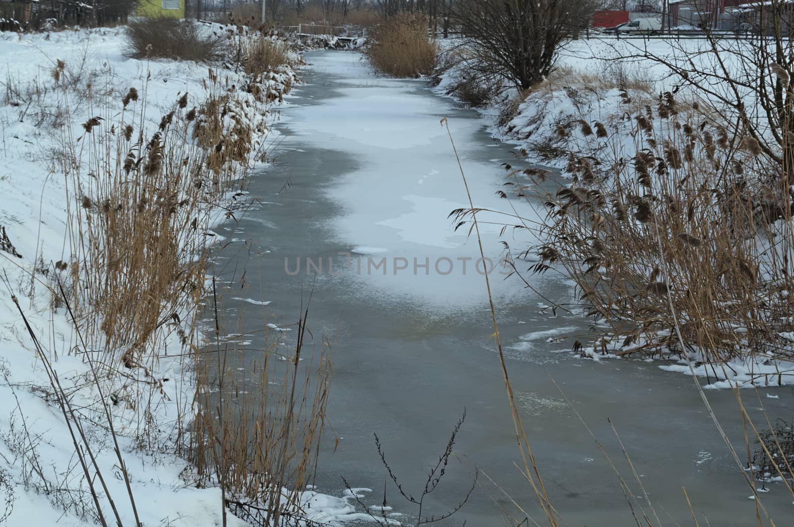 winter landscape with frozen canal and snow all around
