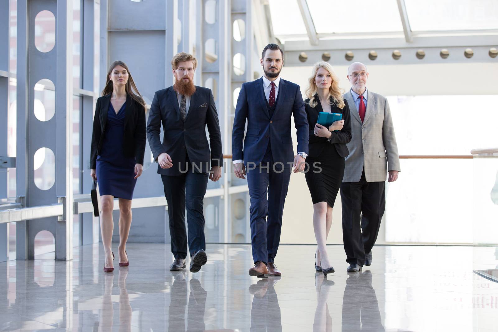 Business team walking in glass building by ALotOfPeople