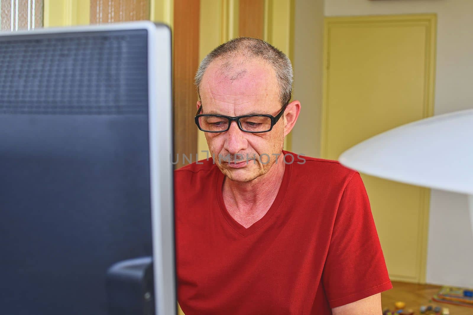 Middle aged man with glasses sitting at desk. Mature man using personal computer. Senior concept.  Man  working at home office. 