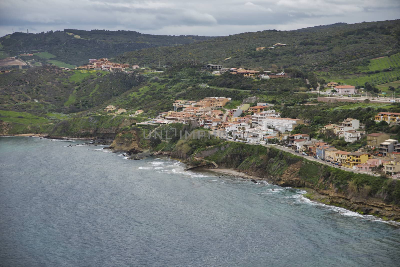 part of castelsardo village on sardinia with the caostline beach and rocks