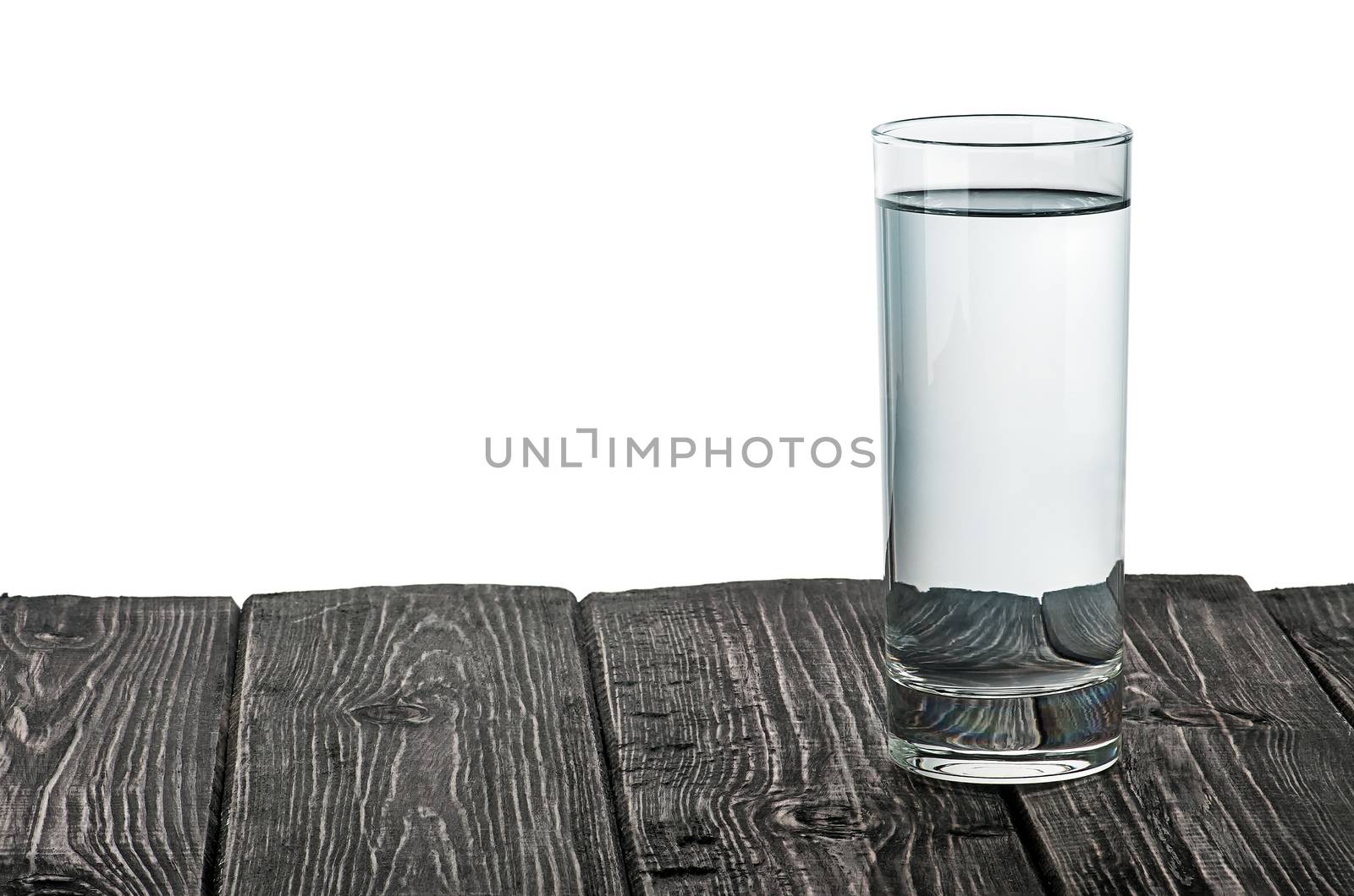 Single glass of water on wooden table isolated on white background