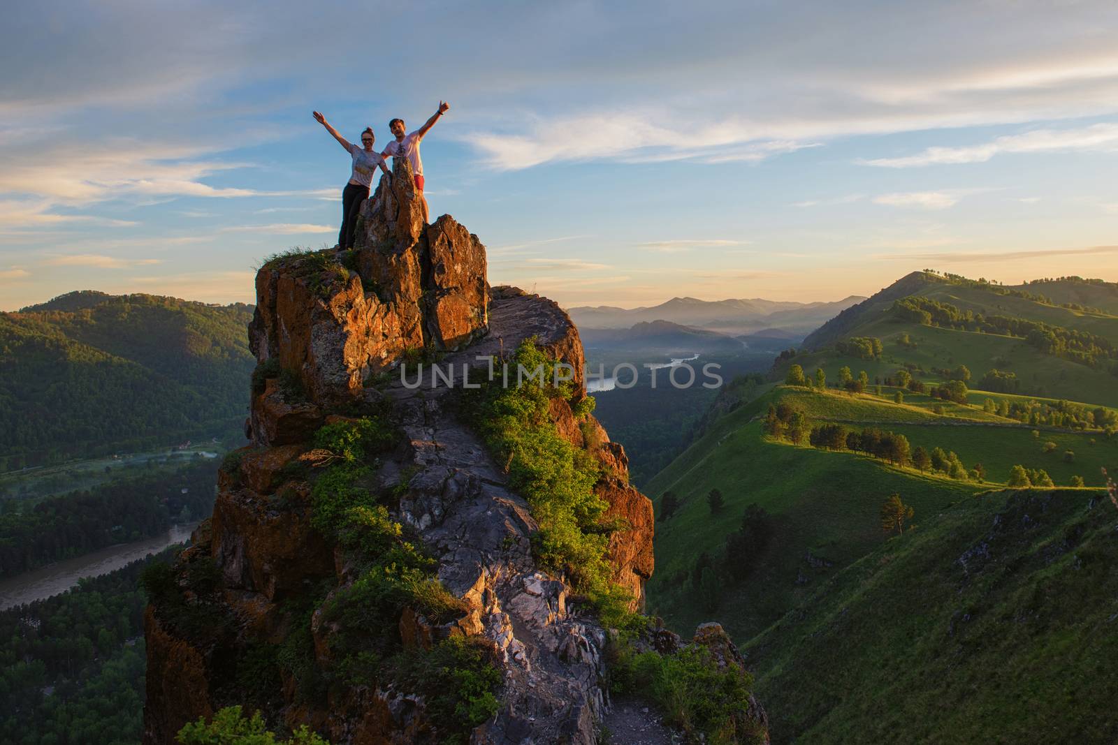 Happy man and woman on top mountain by rusak
