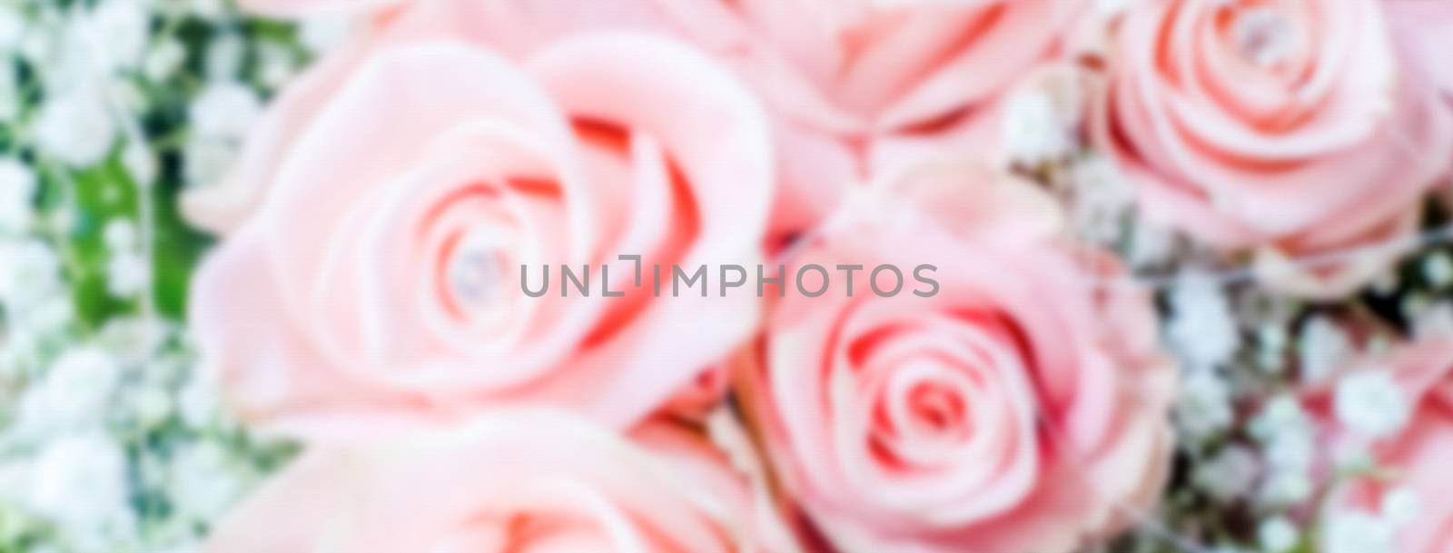 Defocused background with bouquet of pink roses. Intentionally blurred post production for bokeh effect