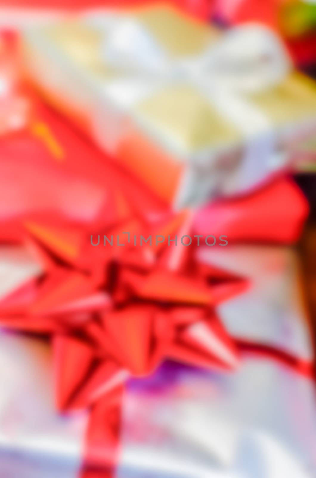 Defocused background of Christmas gifts with red packages by marcorubino