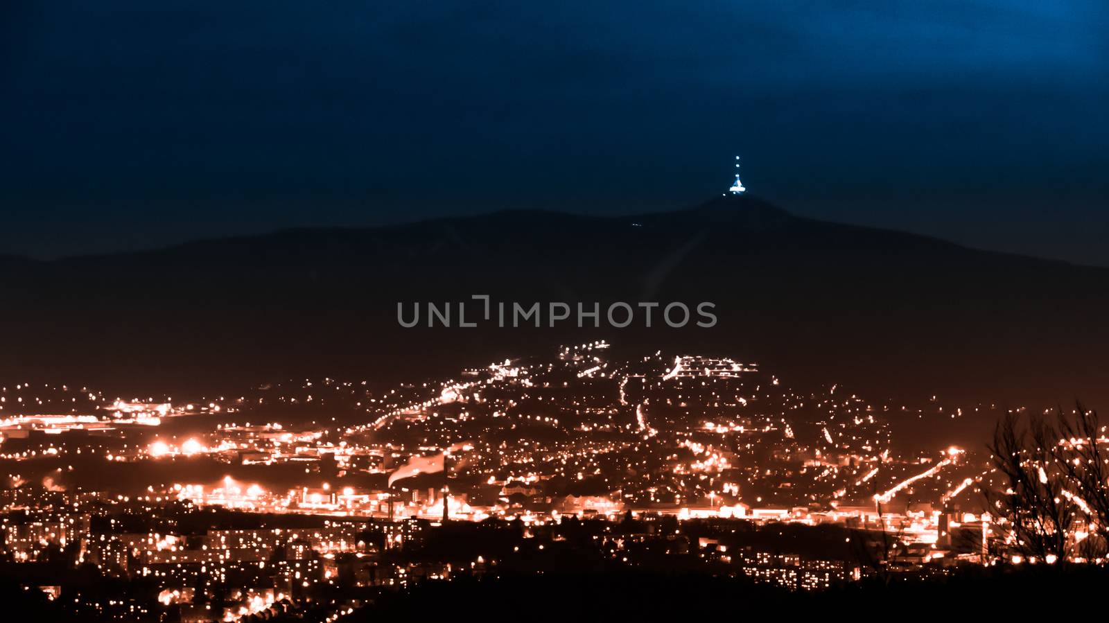 Evening view of illuminated Liberec city and Jested Mountain. Night scene.
